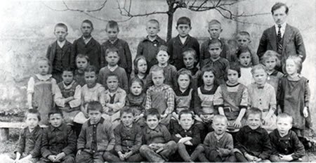 Oberlehrer Sinabel mit seinen Schülern im Schulhof 1925